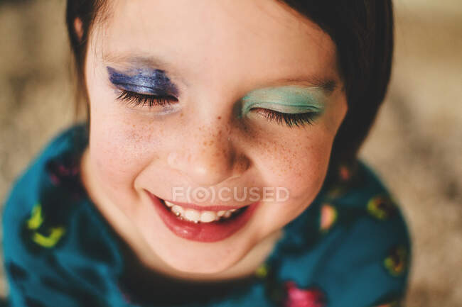 Retrato de uma menina sorridente usando sombra nos olhos — Fotografia de Stock