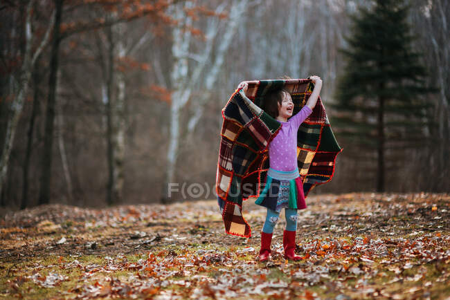 Menina segurando um cobertor girando ao redor — Fotografia de Stock