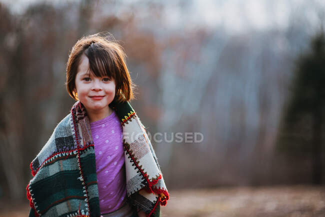 Retrato de una chica envuelta en una manta riendo - foto de stock