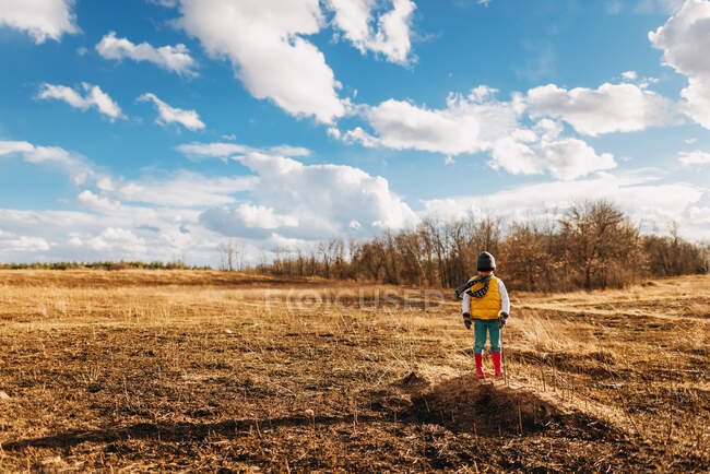 Boy standing in rural landscape on nature — Stock Photo