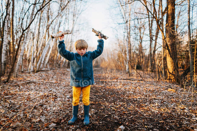 Adorable little boy playing alone in autumnal forest — Stock Photo