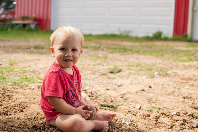 Retrato de un niño jugando en la tierra - foto de stock