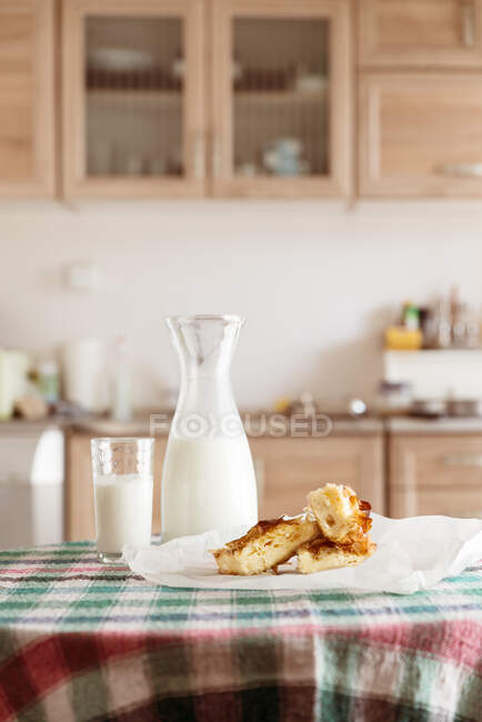 Leite e doces em uma mesa de cozinha — Fotografia de Stock