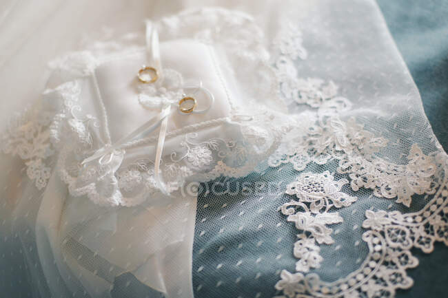 Véu de casamento e anéis de casamento em uma almofada — Fotografia de Stock