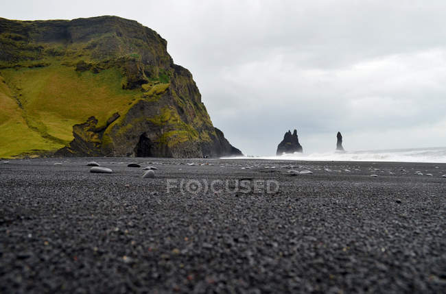 Acantilados de Reynisdrangur y playa de arena negra, Myrdalshreppur, Islandia - foto de stock