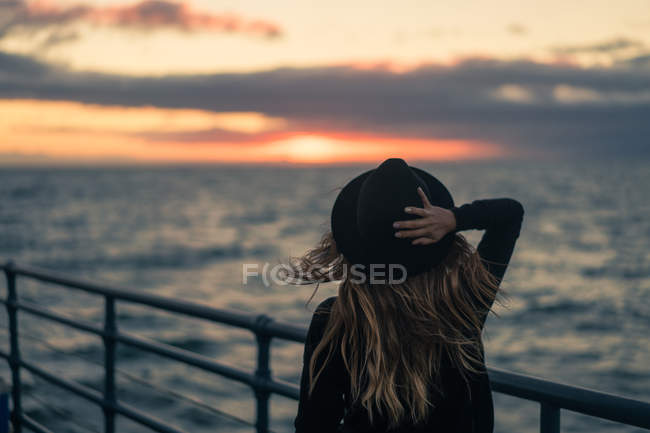 Mulher olhando para o pôr do sol, Santa Monica praia, Califórnia, América, EUA — Fotografia de Stock