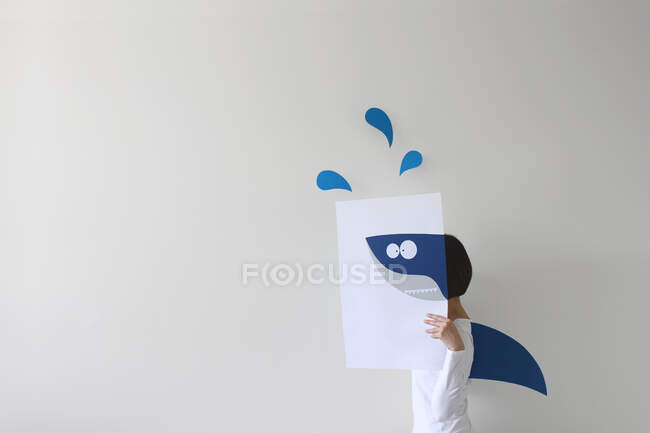 Frau hält Papier mit Hai-Zeichnung in der Hand und trägt Haiflosse — Stockfoto