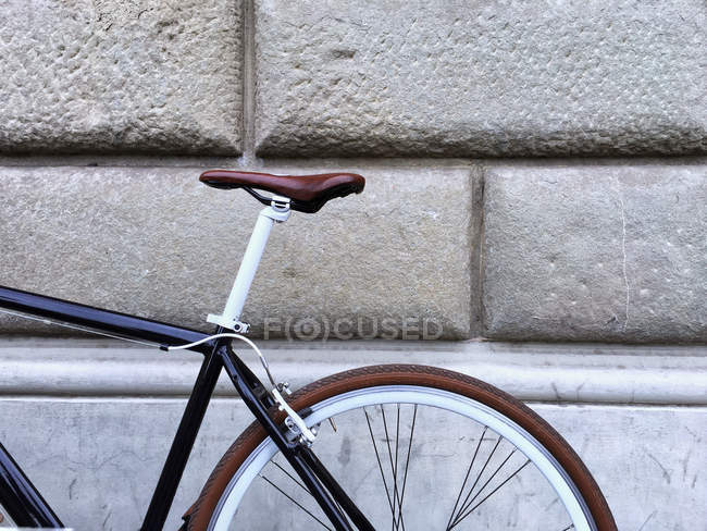 Bicicleta apoyada en una pared de piedra - foto de stock
