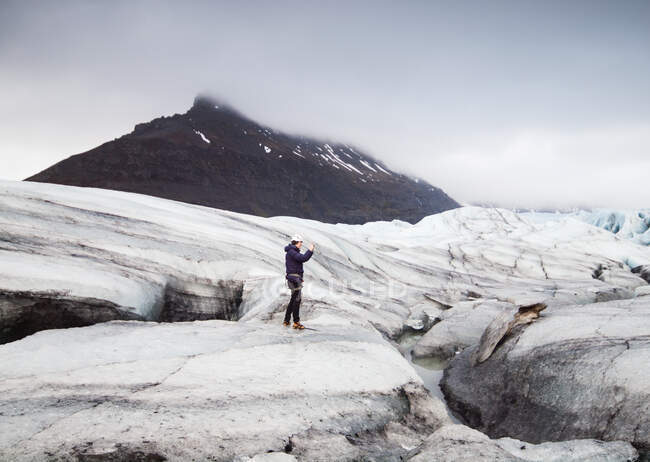 Человек фотографирует ледник, Svinafellsjokull, Исландия — стоковое фото