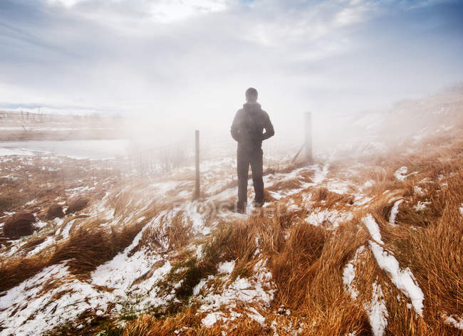 Vista trasera del hombre de pie en el paisaje geotérmico, Islandia - foto de stock