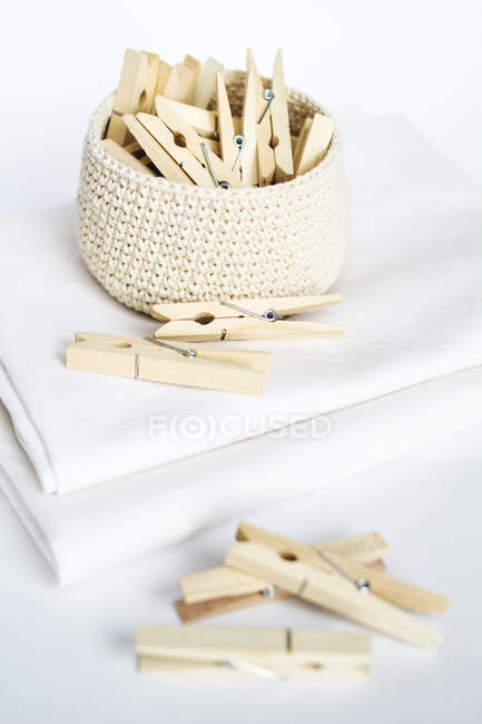 Wooden clothes pegs in knitted basket — Stock Photo