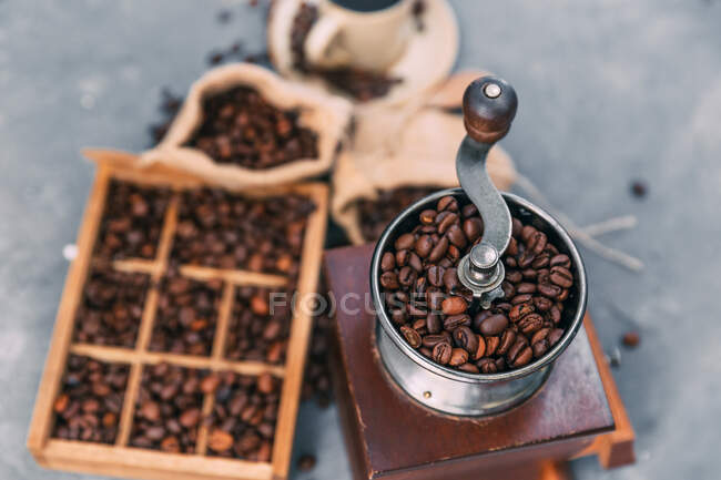 Primer plano de molinillo de café y caja de granos de café - foto de stock