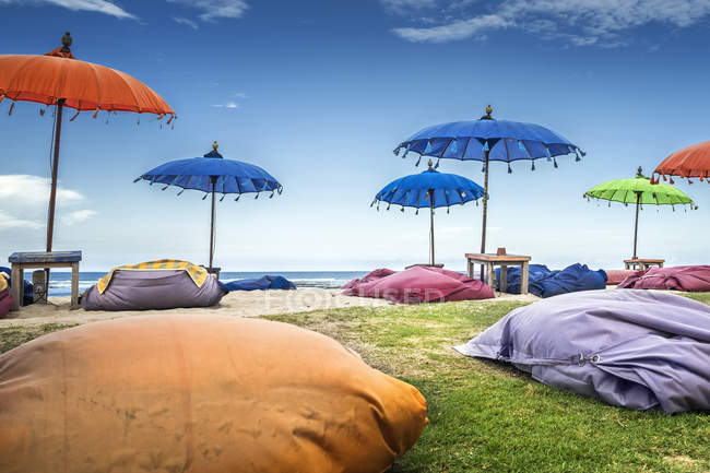 Bunte sitzsäcke und sonnenschirme am strand, bali, indonesien — Stockfoto