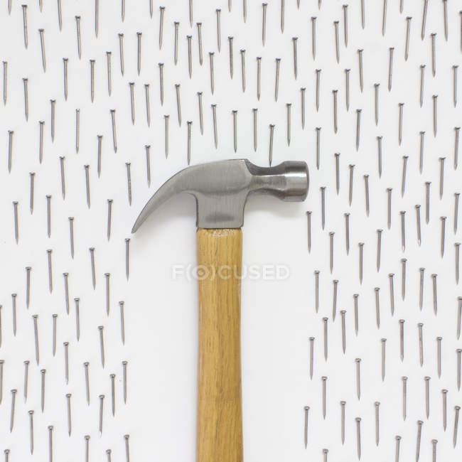 Closeup view of Conceptual umbrella and rain by hammer and nails - foto de stock