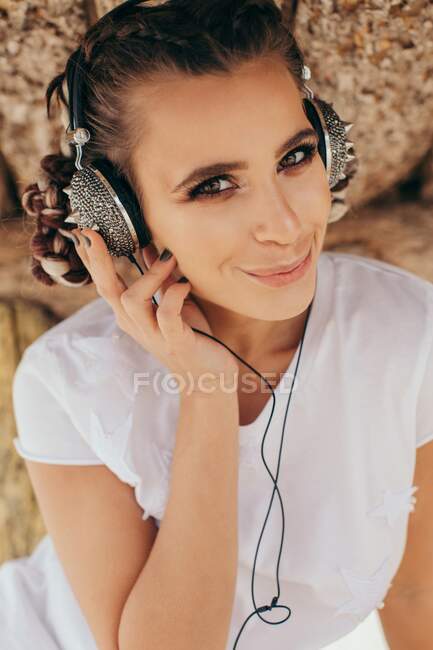 Retrato de una mujer sonriente con auriculares con pinchos - foto de stock
