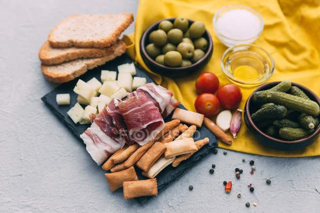 Испанский выбор тапас с ветчиной Серрано, сыром, огурцами и оливками — стоковое фото