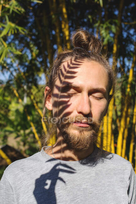 Sombra de uma folha de samambaia no rosto de um homem — Fotografia de Stock