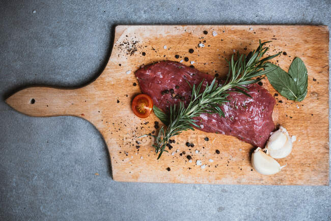 Overhead view of steak with garlic and herbs — Stock Photo
