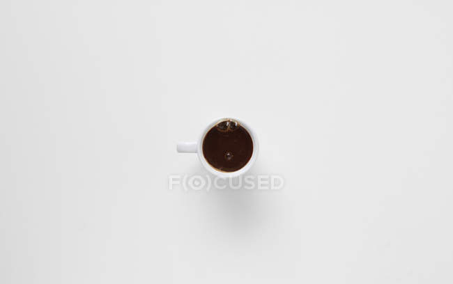 Пузырьки, создающие морщинистое лицо в чашке кофе — стоковое фото