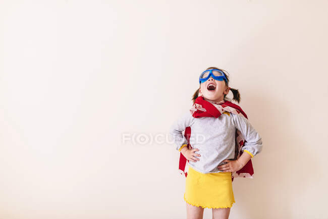 Дівчинка в костюмі супергероя на білому фоні. — стокове фото