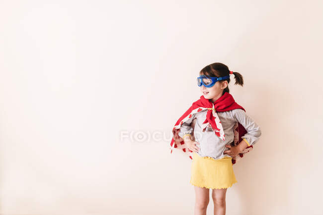 Menina vestida como um super-herói no fundo branco — Fotografia de Stock