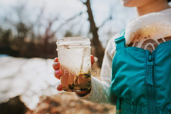 Дівчина біля ставка збирає водяні жучки — стокове фото