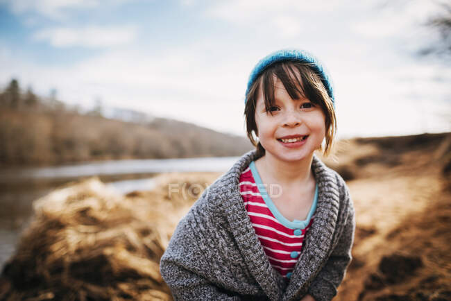 Retrato de una chica sonriente junto a un río - foto de stock