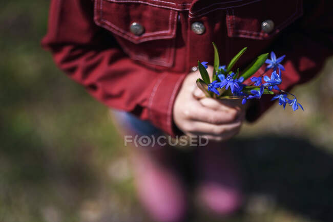 Ragazzo che tiene i fiori vicini — Foto stock