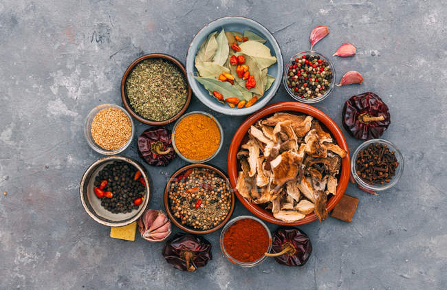 Herbs and spices in bowls over marble table, top view — Stock Photo