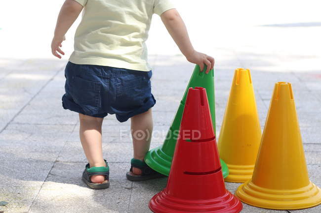Menino brincando com um cone — Fotografia de Stock