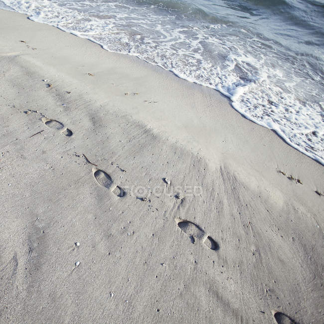 Empreintes de pas dans le sable sur la plage — Photo de stock