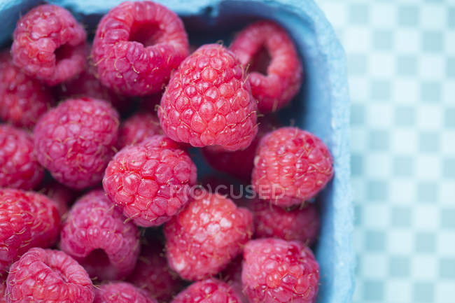 Closeup view of blue box of fresh raspberries — Stock Photo