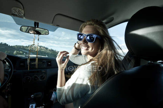 Dos mujeres conduciendo en un coche en un viaje por carretera - foto de stock