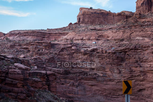 Car driving along cliff in desert landscape, America, USA — Stock Photo