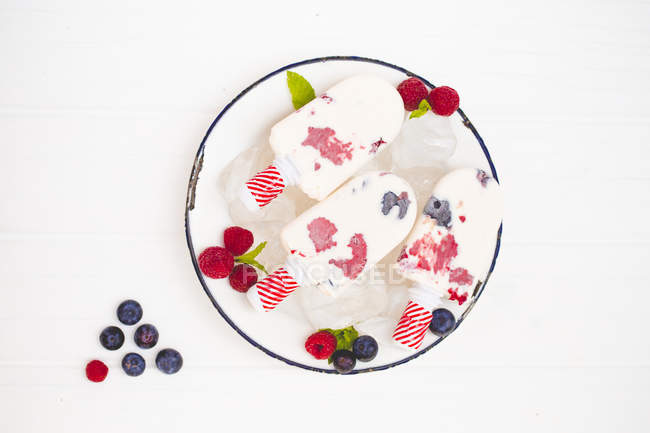 Three milk ice creams, with blueberries and raspberries — Stock Photo