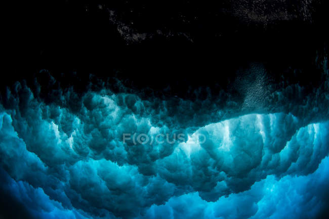 Olas rompiendo en el océano sobre arena negra, Hawai, América, EE.UU. - foto de stock