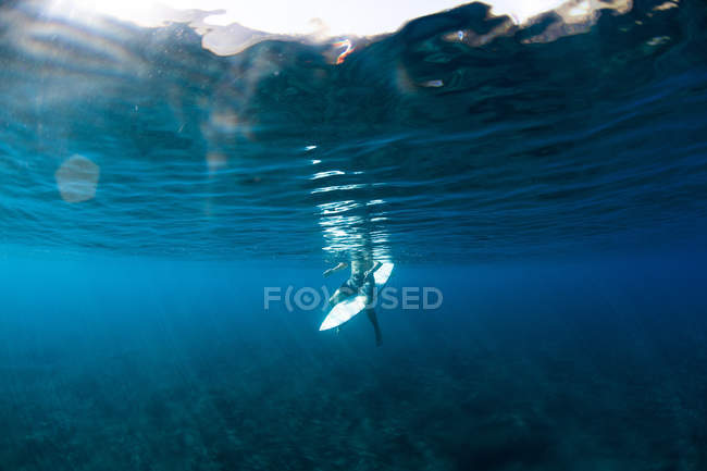 Homme assis sur une planche de surf attendant une vague, Hawaï, Amérique, USA — Photo de stock