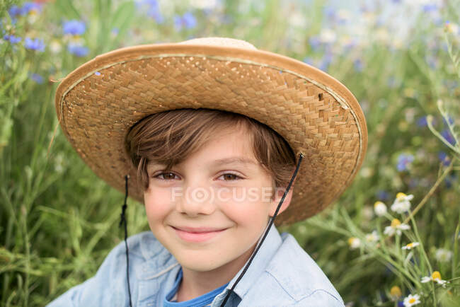 Close-up portrait of smiling boy in straw hat — Stock Photo