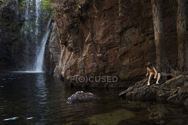 Menino sentado perto de uma cachoeira, Austrália Ocidental, Austrália — Fotografia de Stock