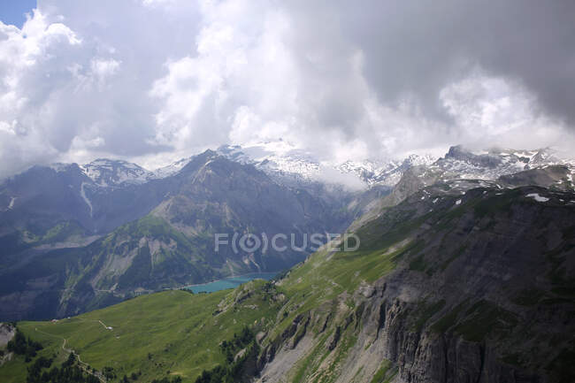 Скелястий гірський пейзаж з озером і хмарним небом — стокове фото