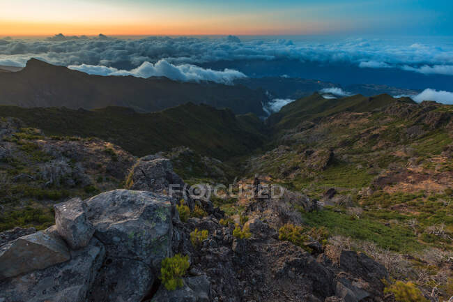 Красивий гірський пейзаж з низькими хмарами і заходом сонця — стокове фото