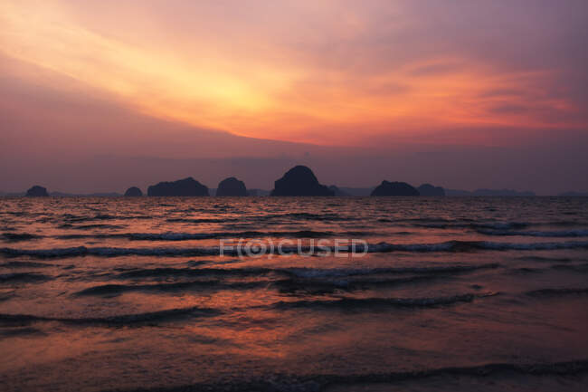 Rocks over rolling sea waves and beautiful sunset sky — Stock Photo