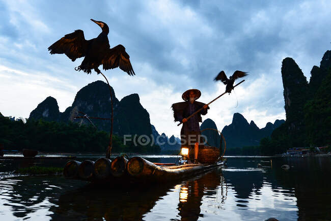 Silluet pescatore di Guilin, fiume Li e montagne carsiche. Xingping, contea di Yangshuo, provincia del Guangxi, Cina. — Foto stock