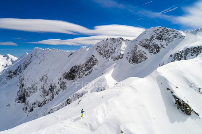 Mujer esquiadora de pie en una cresta de montaña, Sportgastein, Bad Gastein, Salzburgo, Austria - foto de stock