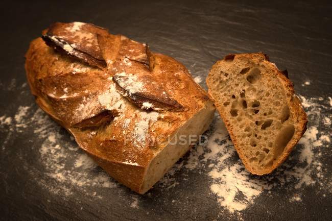 Pan con una rebanada, vista elevada - foto de stock