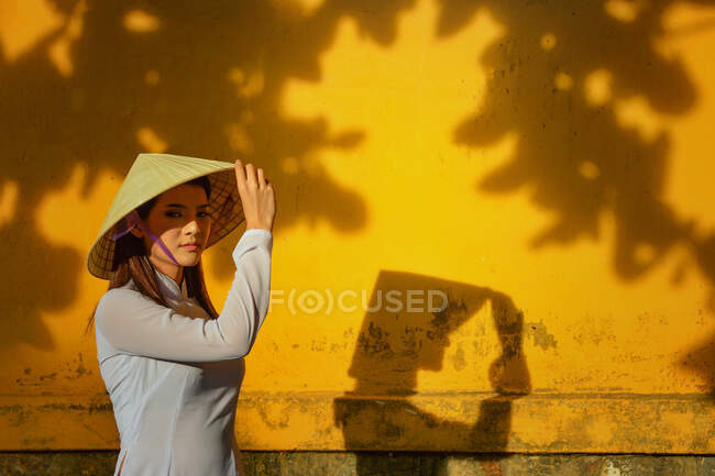 Retrato de una mujer tocándose el sombrero, Vietnam - foto de stock