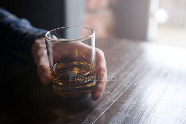 Homme tenant un verre de whisky — Photo de stock