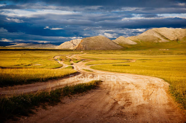 Vue panoramique sur la route de la saleté à travers le paysage rural, Mongolie — Photo de stock
