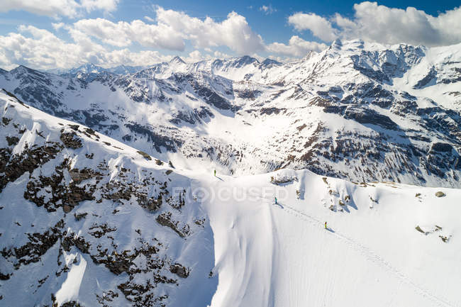 Imagen aérea de un grupo de tres personas esquiando - foto de stock