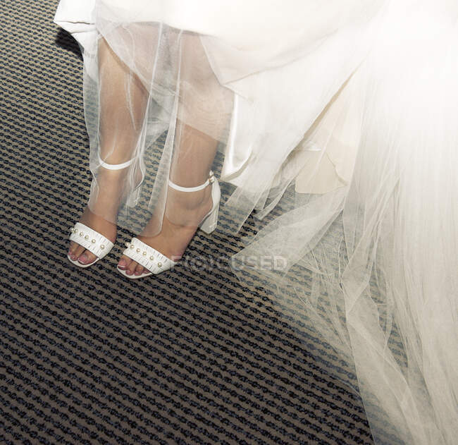 Gros plan d'une mariée dans ses chaussures de mariage — Photo de stock